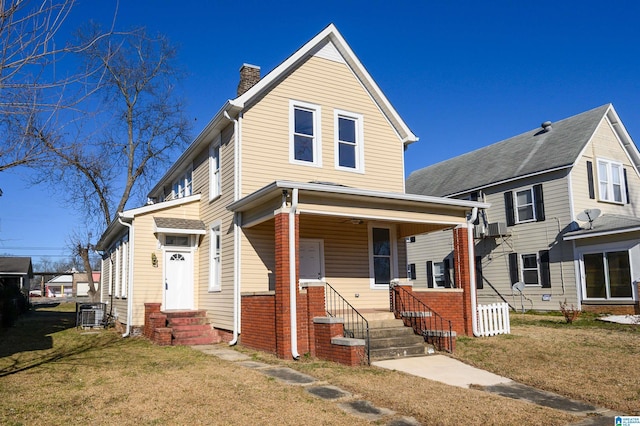 front facade featuring a front yard and central AC