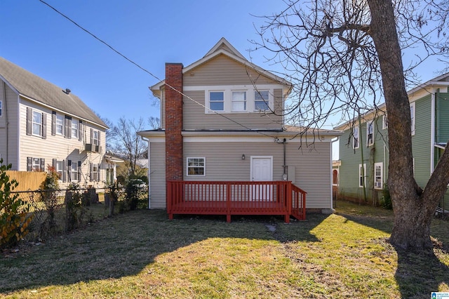 rear view of property featuring a deck and a lawn