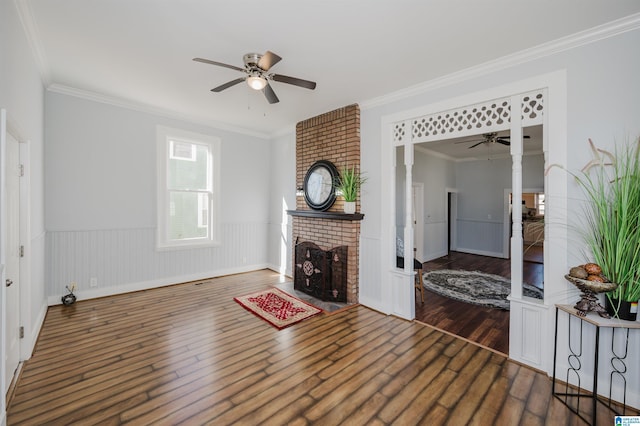 living room featuring crown molding, a fireplace, and dark hardwood / wood-style flooring