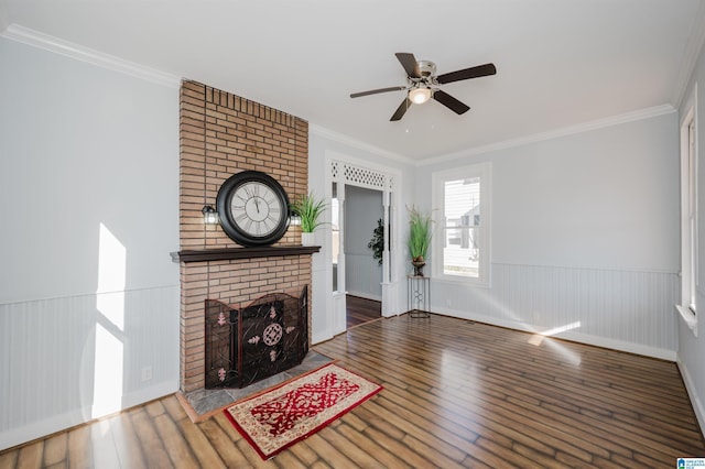 unfurnished living room with crown molding, ceiling fan, a brick fireplace, and dark hardwood / wood-style flooring