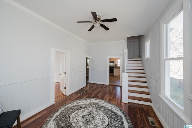 interior space with ceiling fan, wood-type flooring, and ornamental molding