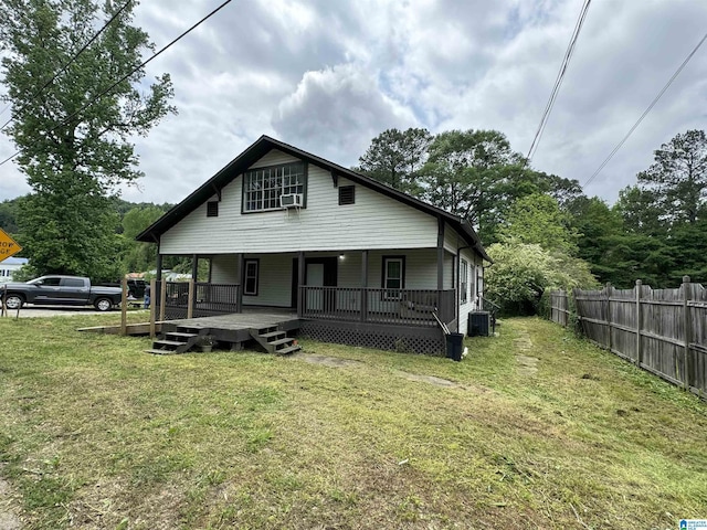 bungalow-style house with covered porch, cooling unit, a front yard, and central AC