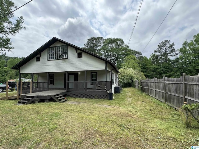 back of property featuring a wooden deck, a lawn, and central AC