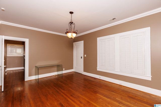 spare room featuring crown molding and dark hardwood / wood-style flooring