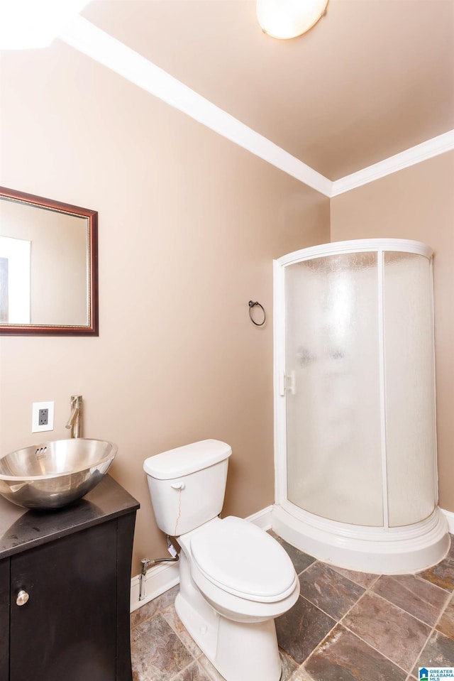 bathroom with vanity, toilet, ornamental molding, and an enclosed shower