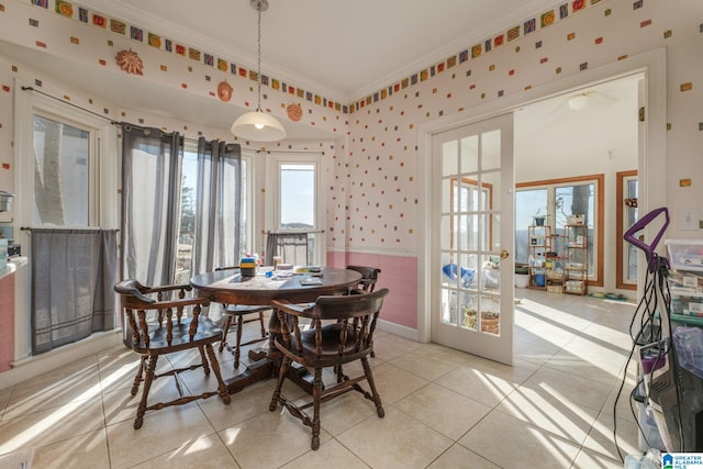 dining area with light tile patterned floors, ornamental molding, and french doors