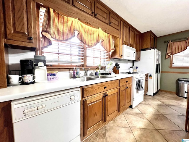 kitchen featuring sink, white appliances, and light tile patterned floors