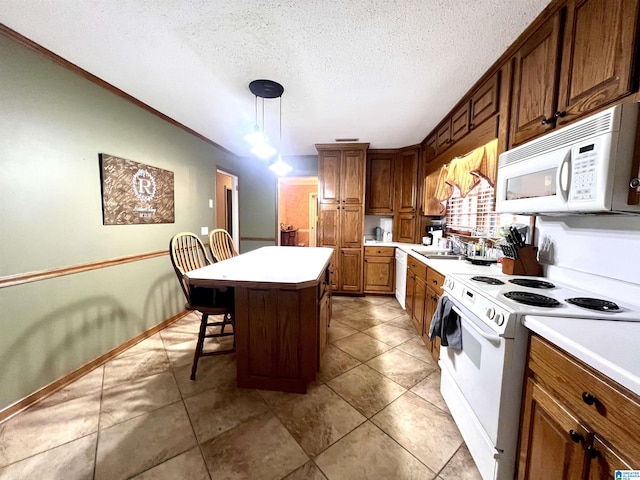 kitchen featuring pendant lighting, sink, white appliances, a kitchen bar, and a kitchen island