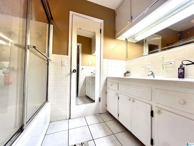 bathroom featuring vanity, bath / shower combo with glass door, tile patterned floors, and tile walls