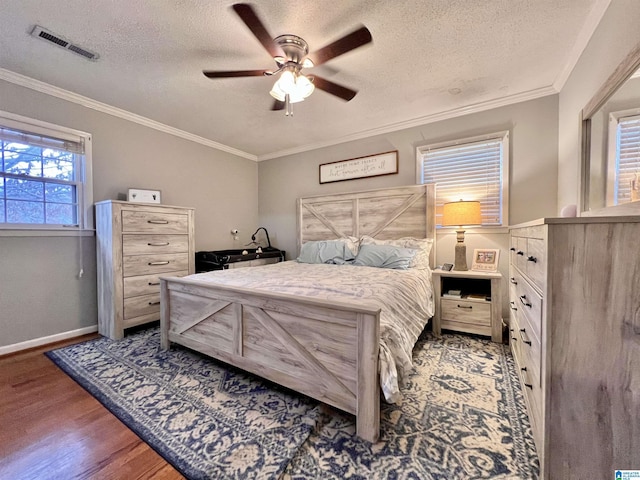 bedroom with ceiling fan, a textured ceiling, dark hardwood / wood-style flooring, and crown molding