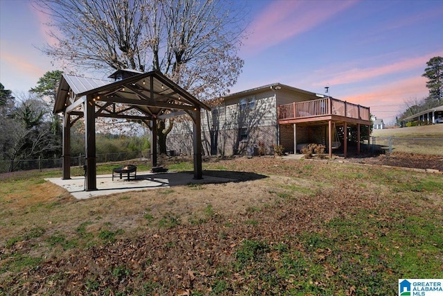 view of yard with a patio, fence, an outdoor fire pit, a wooden deck, and a gazebo