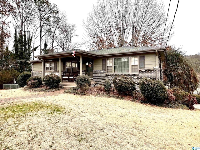 ranch-style home featuring a front lawn and covered porch