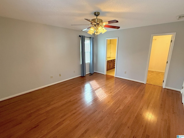 unfurnished room featuring ceiling fan, light hardwood / wood-style flooring, and a textured ceiling