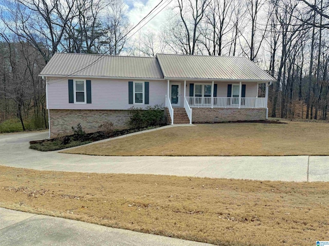 ranch-style house featuring covered porch and a front lawn