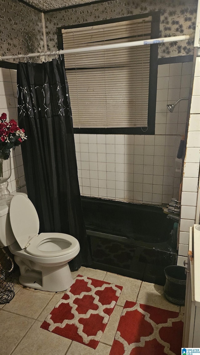 bathroom with tile patterned floors, toilet, and shower / tub combo with curtain