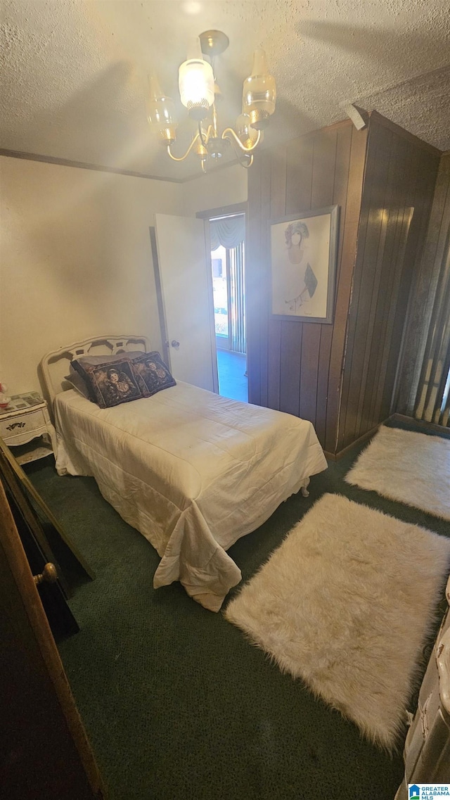 carpeted bedroom with wood walls and a textured ceiling