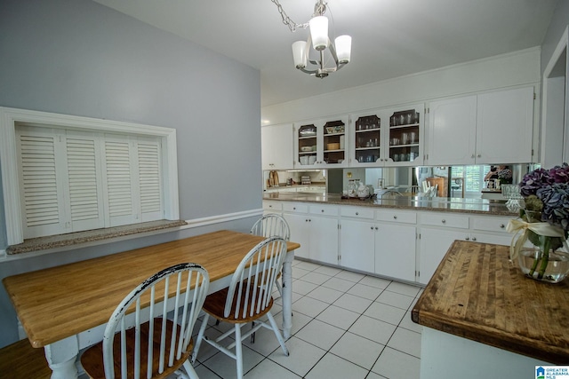 kitchen featuring a notable chandelier, white cabinetry, hanging light fixtures, and light tile patterned floors