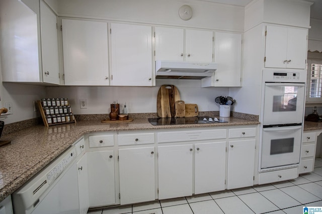 kitchen with light tile patterned floors, white appliances, and white cabinets