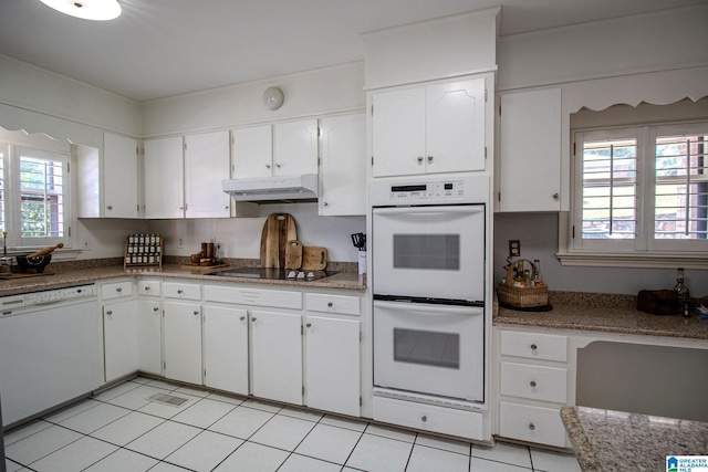 kitchen with white cabinetry, white appliances, and light tile patterned flooring