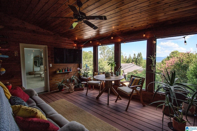 sunroom / solarium with vaulted ceiling, ceiling fan, and wood ceiling