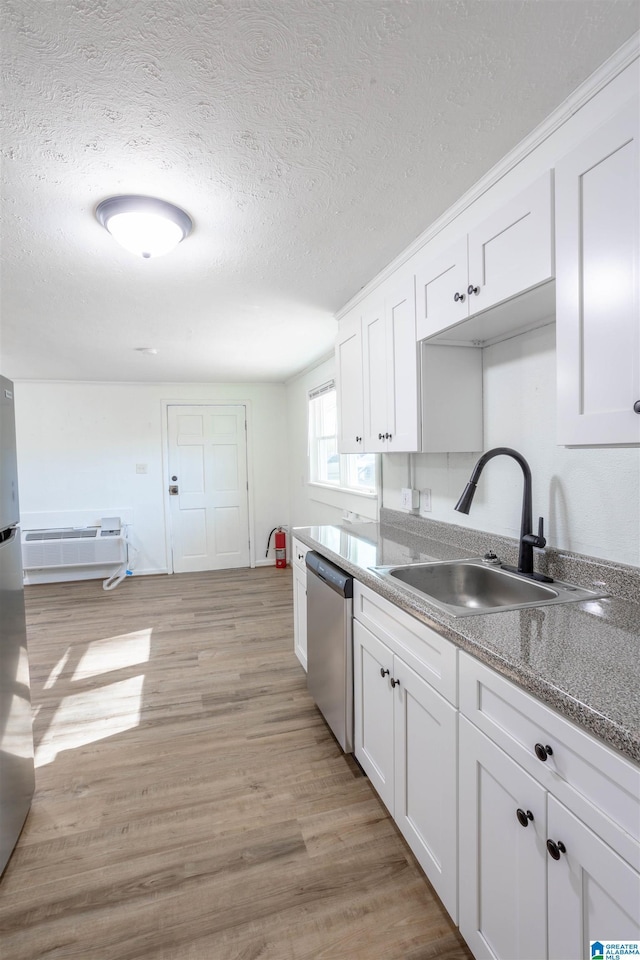 kitchen with a textured ceiling, dishwasher, white cabinetry, sink, and light wood-type flooring