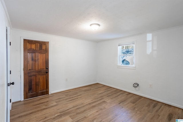 empty room featuring light hardwood / wood-style flooring and ornamental molding