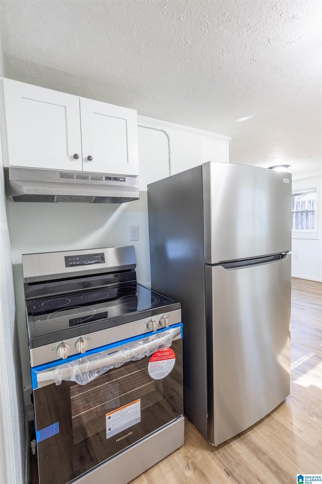 kitchen featuring a textured ceiling, white cabinetry, light hardwood / wood-style flooring, and appliances with stainless steel finishes