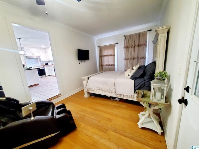 bedroom featuring crown molding, ceiling fan, and light hardwood / wood-style floors