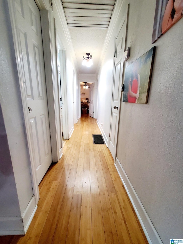 hall with crown molding and light wood-type flooring