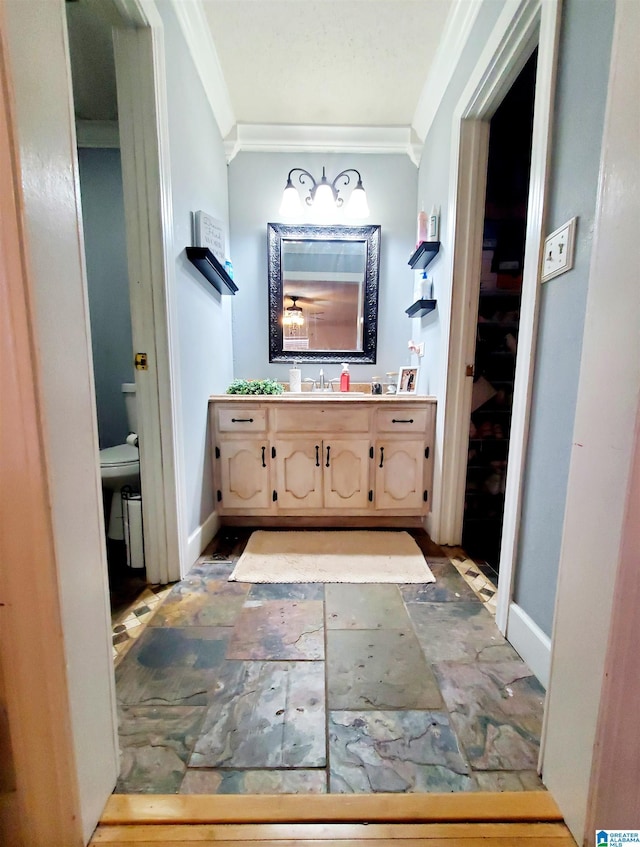 bathroom with crown molding, vanity, and toilet