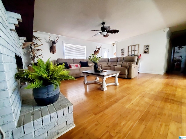 living room featuring ceiling fan, a fireplace, and hardwood / wood-style floors