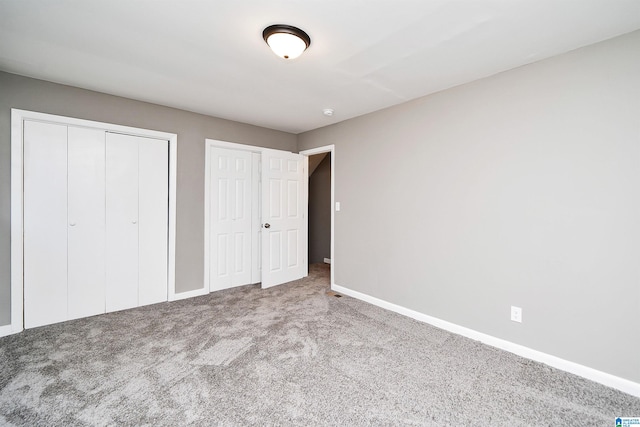 unfurnished bedroom with carpet and two closets