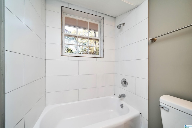 bathroom featuring tiled shower / bath combo and toilet