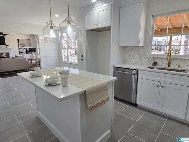 kitchen featuring sink, dishwasher, white cabinetry, dark tile patterned flooring, and decorative light fixtures