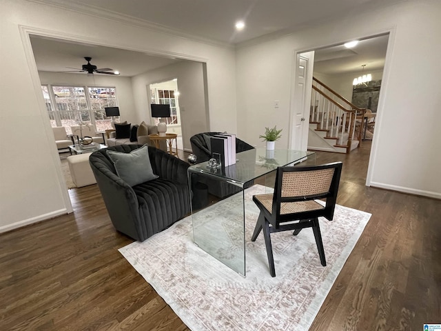 living room featuring crown molding, ceiling fan with notable chandelier, and dark wood-type flooring