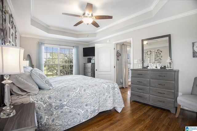 bedroom with ceiling fan, dark hardwood / wood-style floors, a tray ceiling, and crown molding