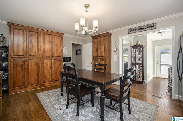 dining area featuring dark hardwood / wood-style flooring, crown molding, and an inviting chandelier