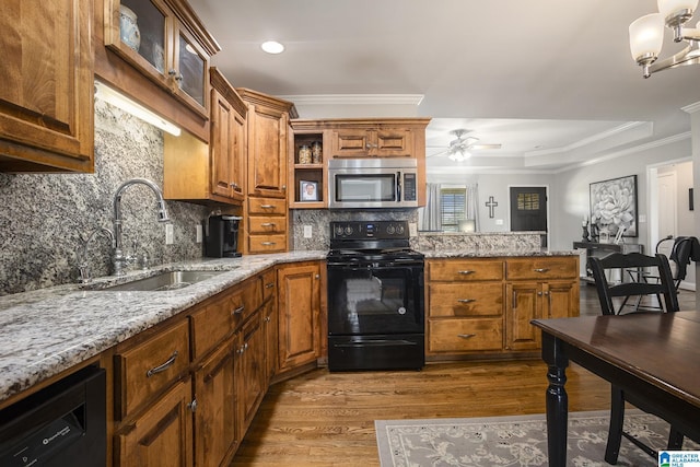 kitchen featuring light hardwood / wood-style flooring, sink, tasteful backsplash, light stone counters, and black appliances