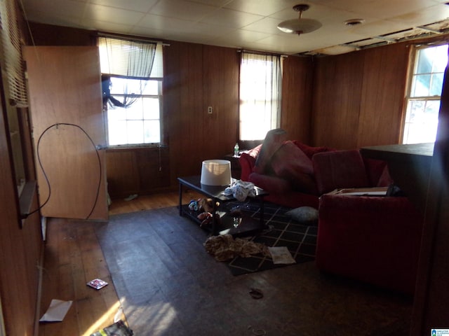 living room featuring a wealth of natural light, wooden walls, and hardwood / wood-style floors