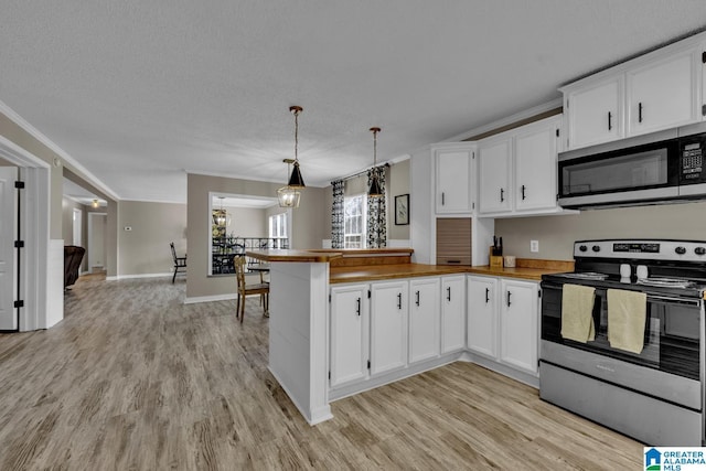 kitchen featuring white cabinets, stainless steel appliances, kitchen peninsula, and decorative light fixtures