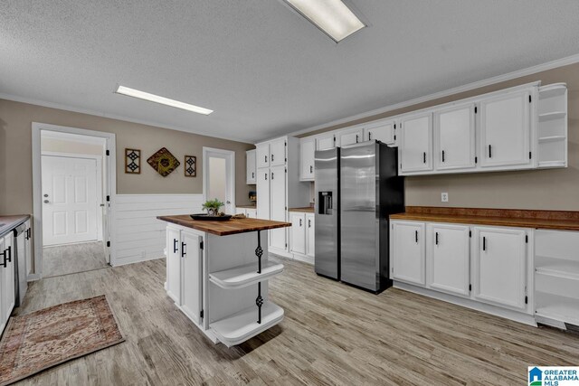 kitchen featuring white cabinetry, butcher block countertops, and stainless steel fridge with ice dispenser