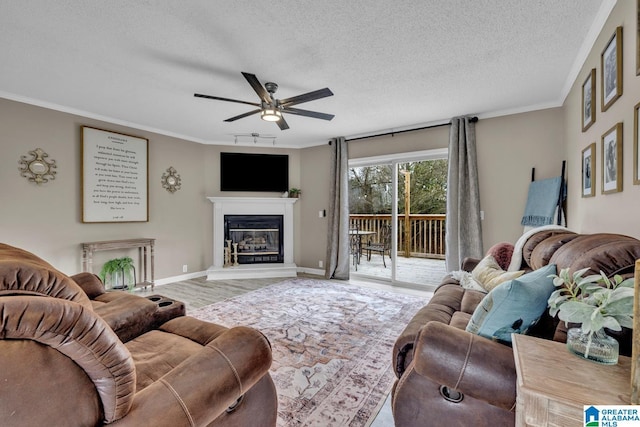 living room featuring crown molding, a textured ceiling, light hardwood / wood-style flooring, and ceiling fan