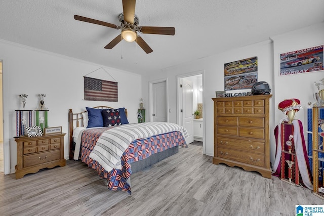 bedroom featuring ceiling fan, a textured ceiling, light hardwood / wood-style flooring, and ensuite bathroom