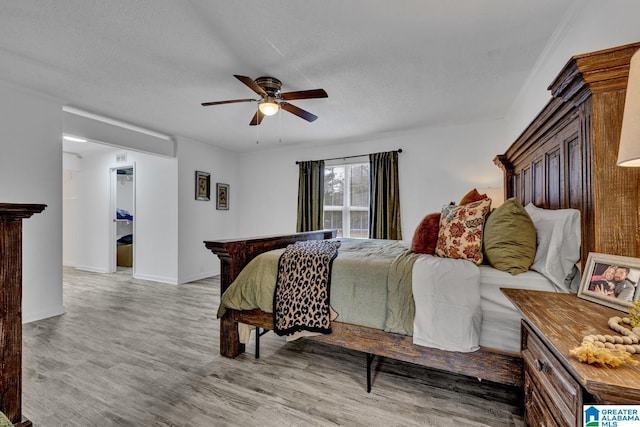 bedroom featuring ceiling fan, a textured ceiling, and light hardwood / wood-style flooring