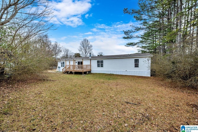 back of property with a lawn and a deck