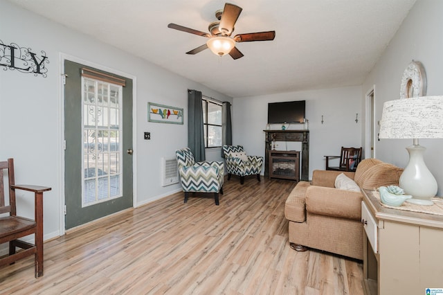 living room with light hardwood / wood-style floors and ceiling fan