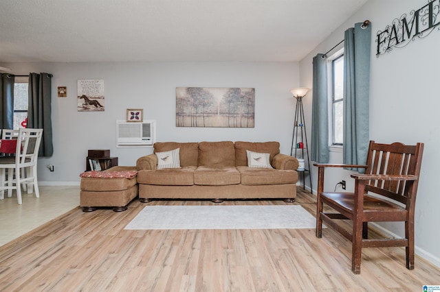 living room featuring light hardwood / wood-style flooring and a wall unit AC