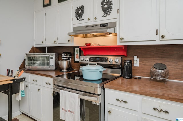 kitchen featuring backsplash, stainless steel range with electric stovetop, butcher block countertops, and white cabinets