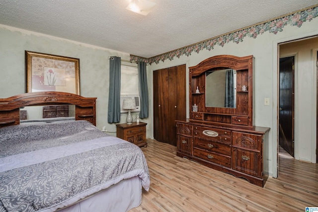 bedroom with a textured ceiling and light hardwood / wood-style flooring