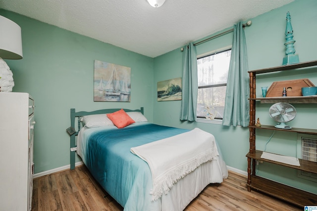 bedroom featuring wood-type flooring and a textured ceiling